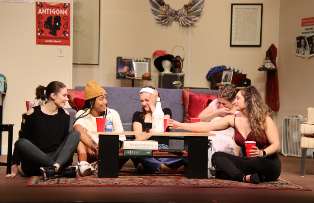 five girls sitting around a sofa during a drunken party